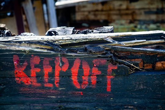 Keep off sign on Rotting Wooden Structure of an old cargo  barge