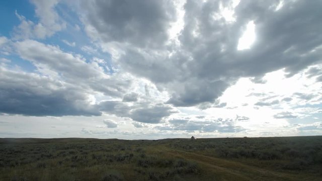 SUV Drives Over Open Prairie Towards Sunset In Afternoon