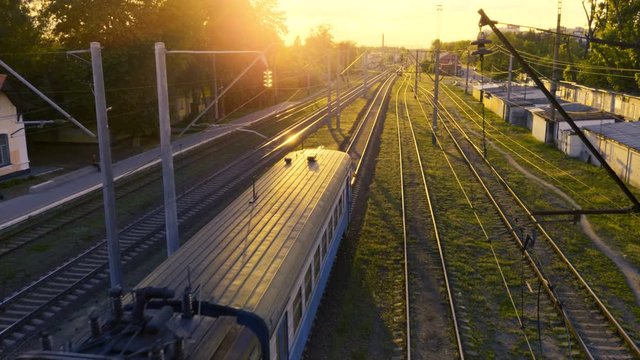 Aerial view of suburban electric train rides at sunset 