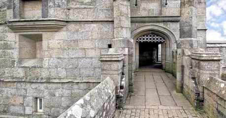 Entrance to an old stone walled castle with portcullis