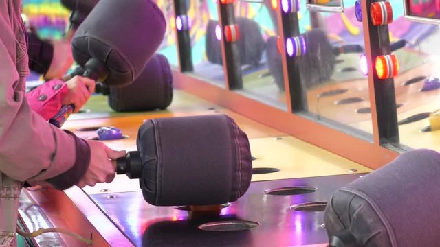 Slow motion of people playing whack game at the West Coast Amusements Carnival