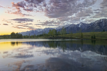 Fototapeta na wymiar Dramatic Sunset Sky and Scenic Springtime Landscape at Quarry Lake above City of Canmore near Banff National Park, Canadian Rocky Mountains