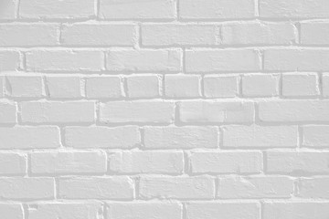 Faded white painted brick wall surface with highlights and shadows. Neutral light gray flat texture and pattern. Architectural masonry work on a building.