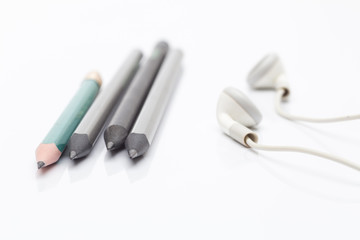 Pencils drawing and a white headphone on a white background