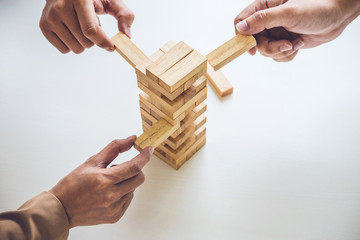 Alternative risk plan and strategy in business, Young intelligent business team playing the wood...