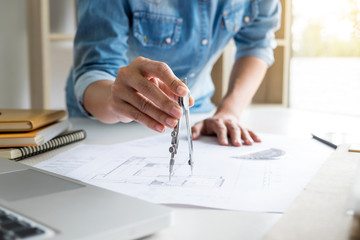 Architect working on blueprint, Engineer working with engineering tools for architectural project on workplace, Construction concept - building project, blueprints, ruler and dividers