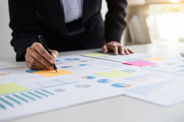 Female accountant calculations and analyzing financial graph data with calculator and laptop Business, Financing, Accounting, Doing finance, Economy, Savings Banking Concept