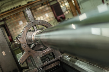 Old mechanic circular drum cylinder machine working at the factory