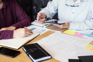 Education, teaching, learning, technology and people concept. Two high school students or classmates with helps friend catching up workbook learning in classroom, Tutor books with friends