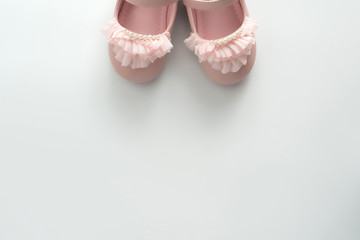 Cute pink baby girl shoes close up on white background