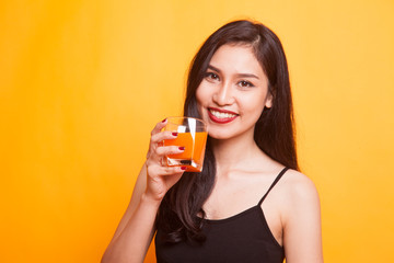 Young Asian woman drink orange juice show OK sign.