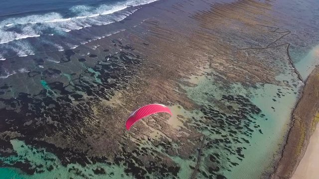 Red hang-glider floats over the ocean Freedom Beautiful view Bali holidays