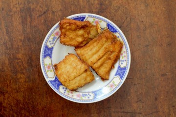 Fried fish fillet On plate Chinese style wood background.