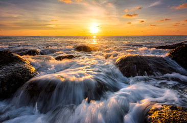 Seascape awesome wave on the rock with coloful sunset at beach in phuket thailand.