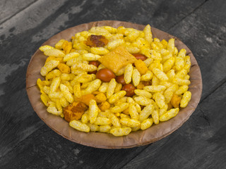 Indian Street Spicy Food Bhel puri is a savoury snack, and is also a type of chaat. It is made of puffed rice, vegetables and a tangy tamarind sauce. on Wooden Background