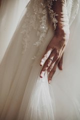 stylish happy bride hand on luxury wedding dress. amazing modern gown in sunny light at window,...