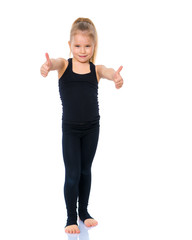 Little gymnast girl shows thumb up.