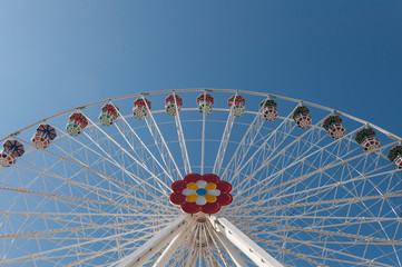 Ferris wheel and the blue sky in the amusement park. Family fun ride.