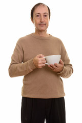 Studio shot of mature man holding coffee cup