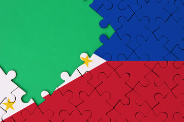 Philippines flag  is depicted on a completed jigsaw puzzle with free green copy space on the left...