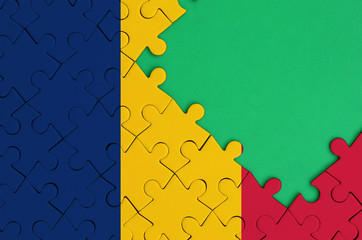 Chad flag  is depicted on a completed jigsaw puzzle with free green copy space on the right side