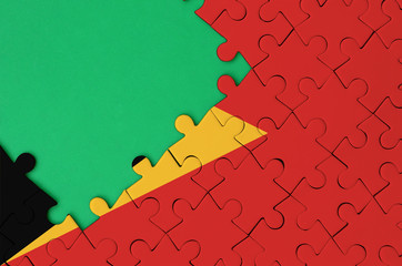 Timor Leste flag  is depicted on a completed jigsaw puzzle with free green copy space on the left...