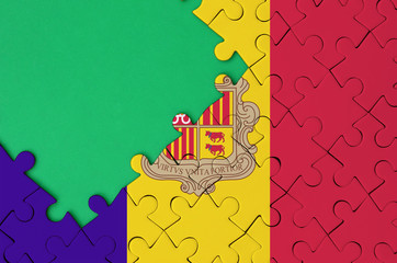 Andorra flag  is depicted on a completed jigsaw puzzle with free green copy space on the left side