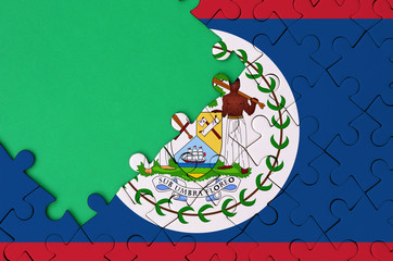 Belize flag  is depicted on a completed jigsaw puzzle with free green copy space on the left side