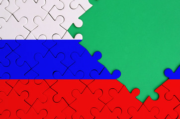 Russia flag  is depicted on a completed jigsaw puzzle with free green copy space on the right side