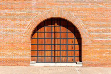 Ancient Russian wooden gate in a brick red wall of the Kremlin