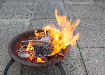 Wood burning brightly in a metal fire pit