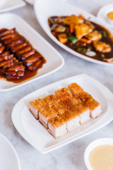 Close up Golden Crispy Pork Belly cut in cube served in white plate.