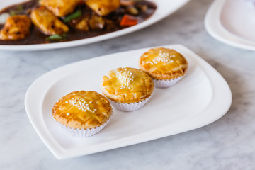Fresh Baked Cantonese BBQ Pork Pies topping with white sesame served in white plate on marble top table.