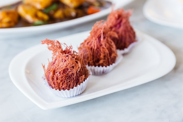 Deep Fried Taro Pao Puff with taro cream inside served in white plate on marble top table.