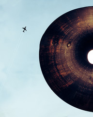 Old lamp and plane flying in the sky
