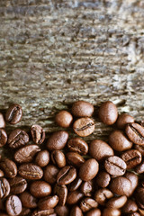 Naklejka premium Roasted coffee beans on rustic wooden background. Food ingredients, top view, space for text