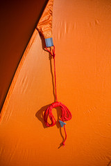 Closeup of details of an orange camping tent. Bright orange color.  Shallow depth of field.