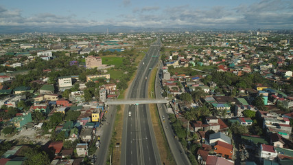 Aerial view of highway with road junction, car and traffic in Manila, Philippines. Highway in Manila among residential buildings. View of highway intersection.