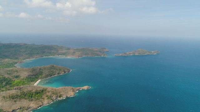 Aerial view of coast with beaches, island Limbones, lagoons and coral reefs. Neela cove, Philippines, Luzon. Coast ocean with turquoise water. Tropical landscape in Asia.