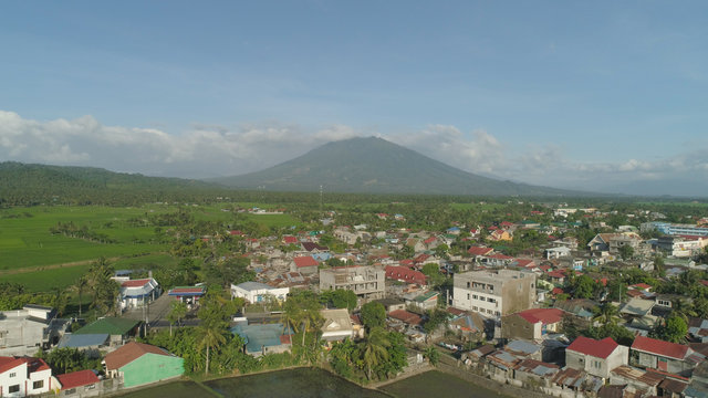 Aerial view of town in a mountain valley at the foot of the mountain Iriga. Luzon, Philippines. Mountainous tropical landscape.