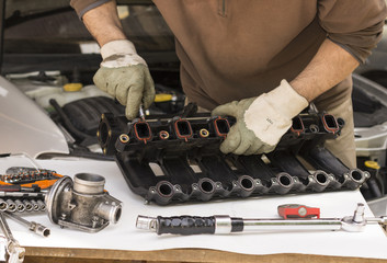 Démontage d'une pièce défectueuse sur une pipe d'admission de véhicule diesel