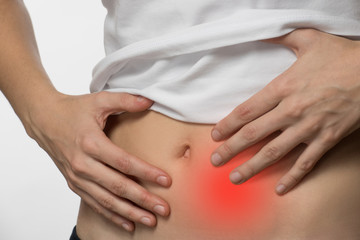 Pain and cramps in the abdomen of a beautiful girl on a white background