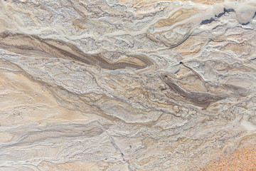 Naklejka premium Beautiful sand patterns on the shore of baltic sea. Abstract, colorful background of sand on the beach. Shallow depth of field.