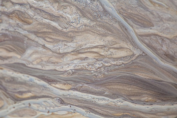 Beautiful sand patterns on the shore of baltic sea. Abstract, colorful background of sand on the beach. Shallow depth of field.