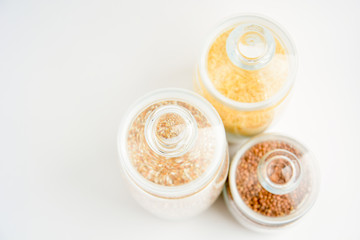 three transparent containers with a grain of rice, buckwheat and lentils. view from above