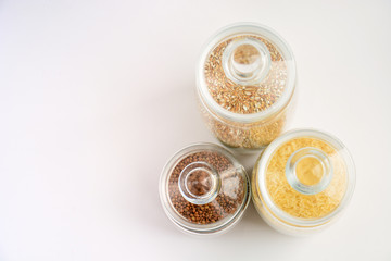three transparent containers with a grain of rice, buckwheat and lentils. view from above