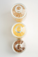 three transparent containers with a grain of rice, buckwheat and lentils. view from above
