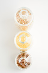 three transparent containers with a grain of rice, buckwheat and lentils. view from above