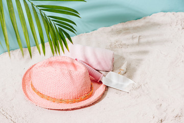 Sandy beach with towel, hat and summer accessories with copy space. Vacation and travel items. Tropical Holiday Background.