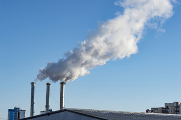 industrial smoke from chimney on blue sky.